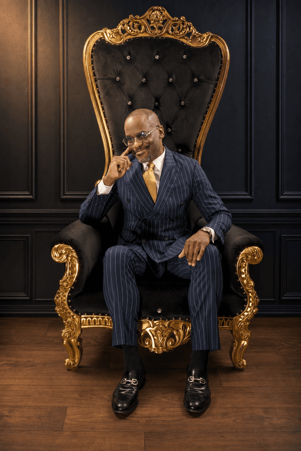 Dr. Glenn Toby seated on a gold baroque throne